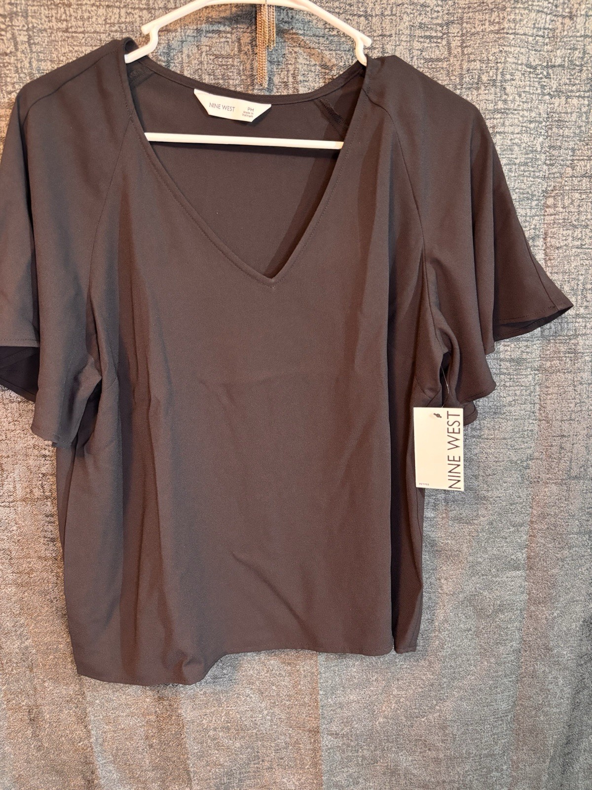 Nine West blouse features a v-neckline and flutter sleeves.