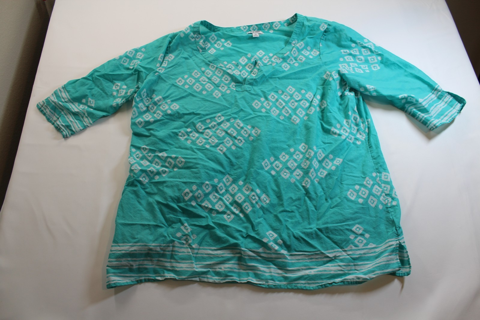 This turquoise Old Navy tunic features a white geometric diamond pattern