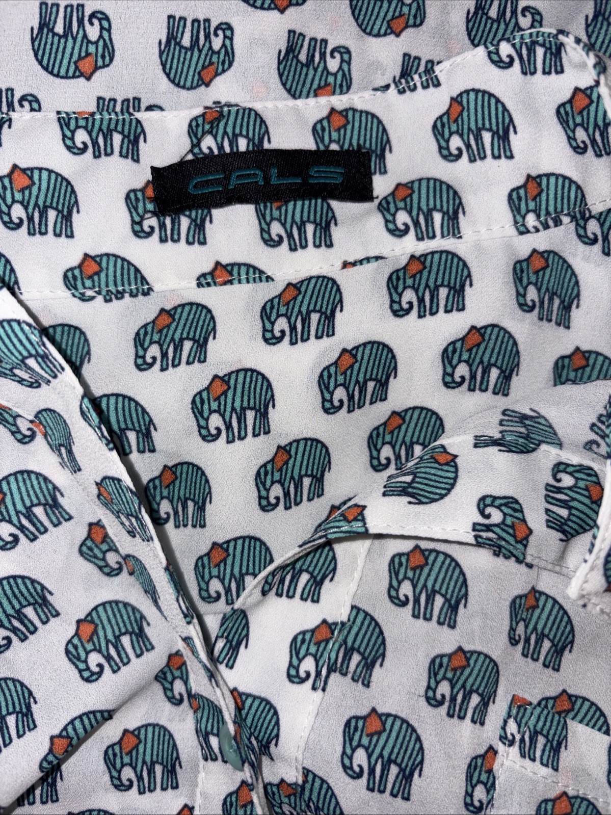 Cals blouse featuring an allover green elephant print on a rich White size Large