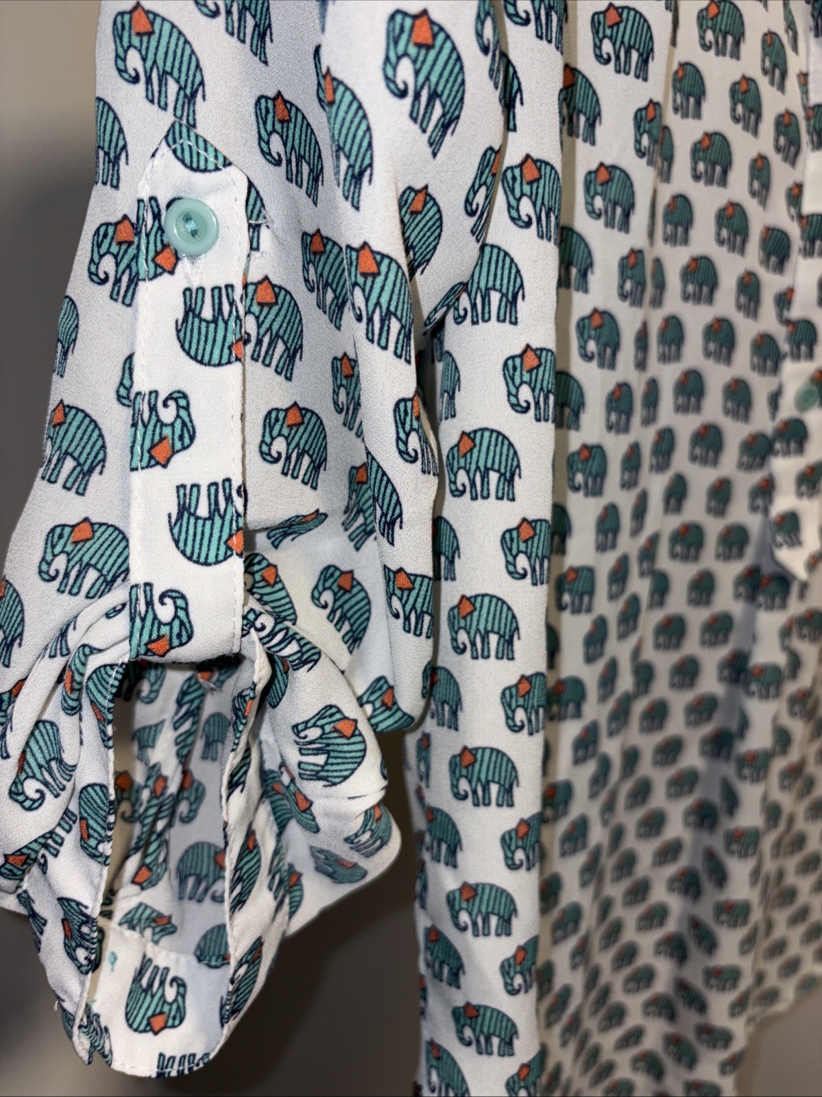 Cals blouse featuring an allover green elephant print on a rich White size Large
