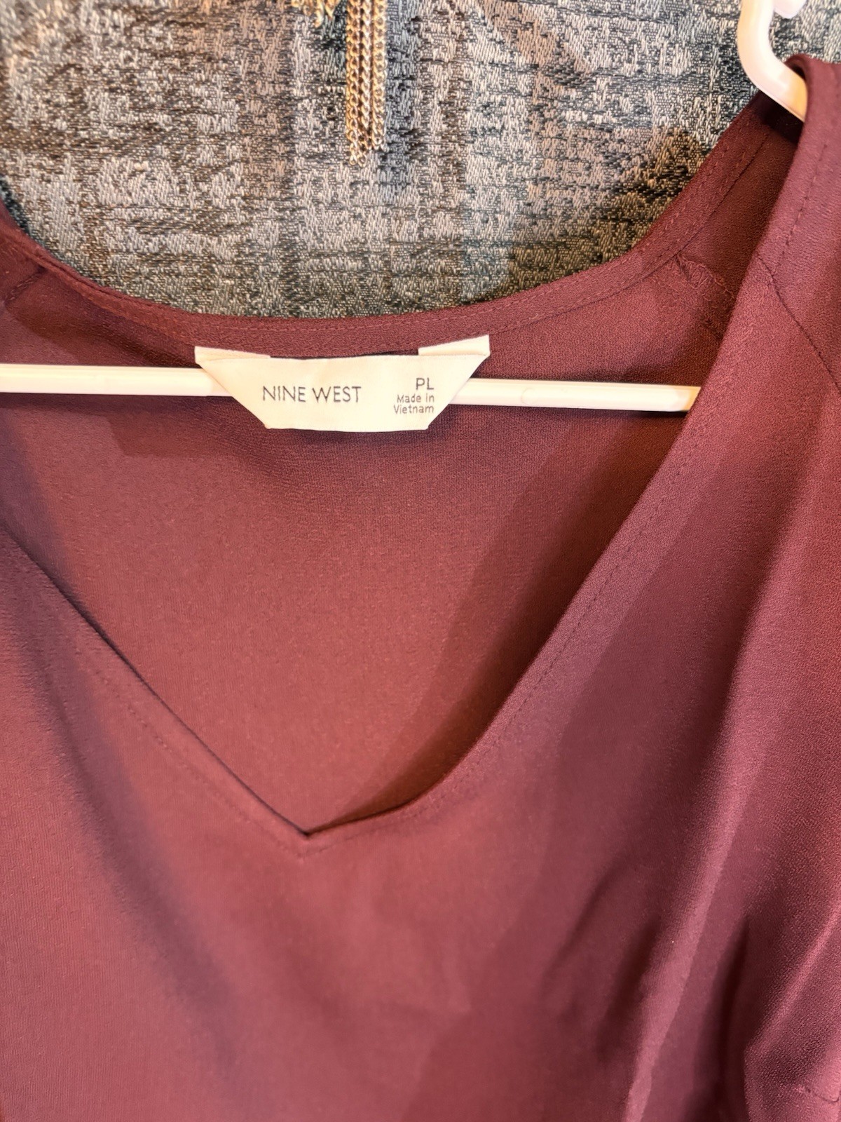 Nine West blouse features a v-neckline and flutter sleeves.