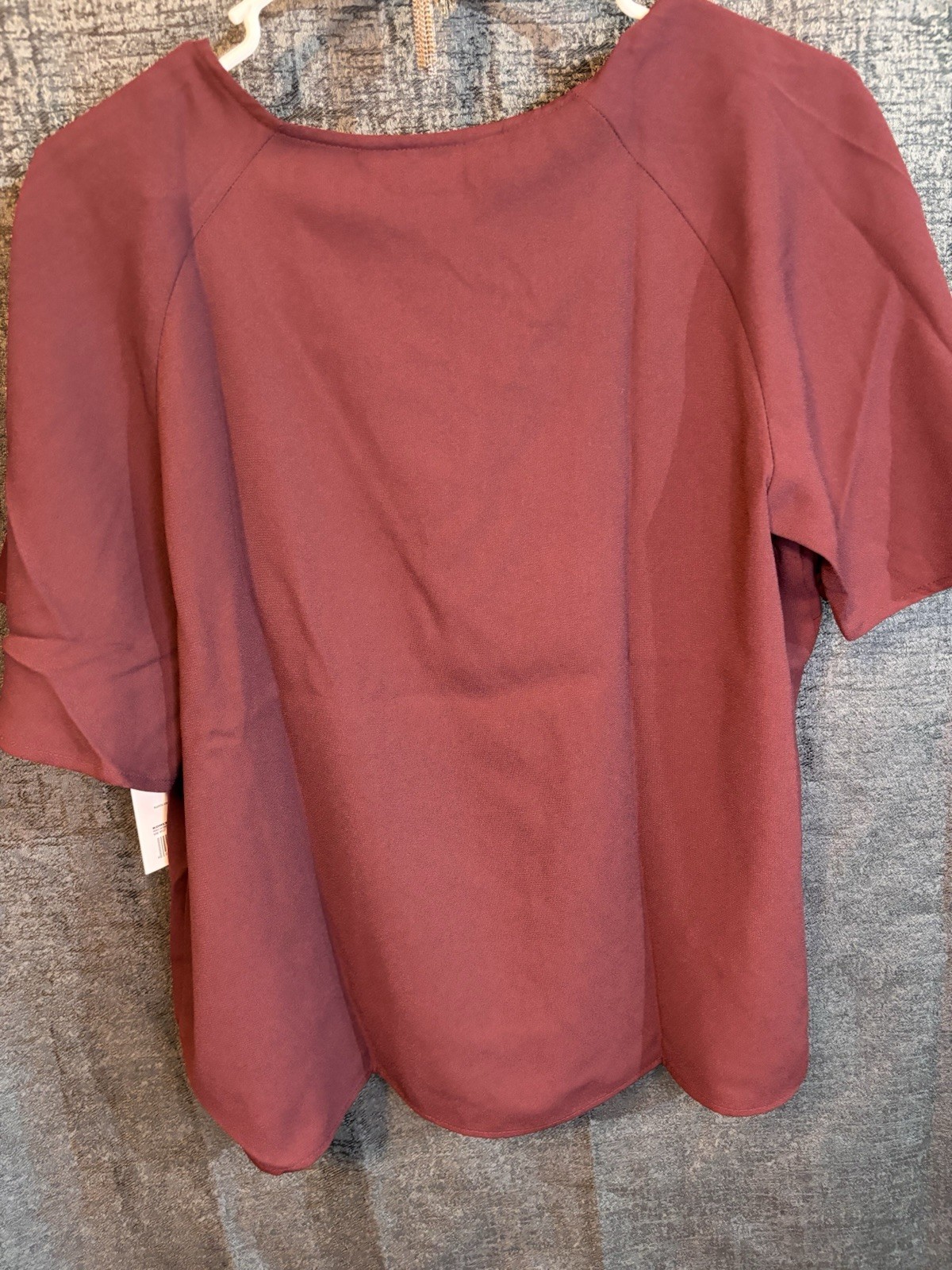 Nine West blouse features a v-neckline and flutter sleeves.