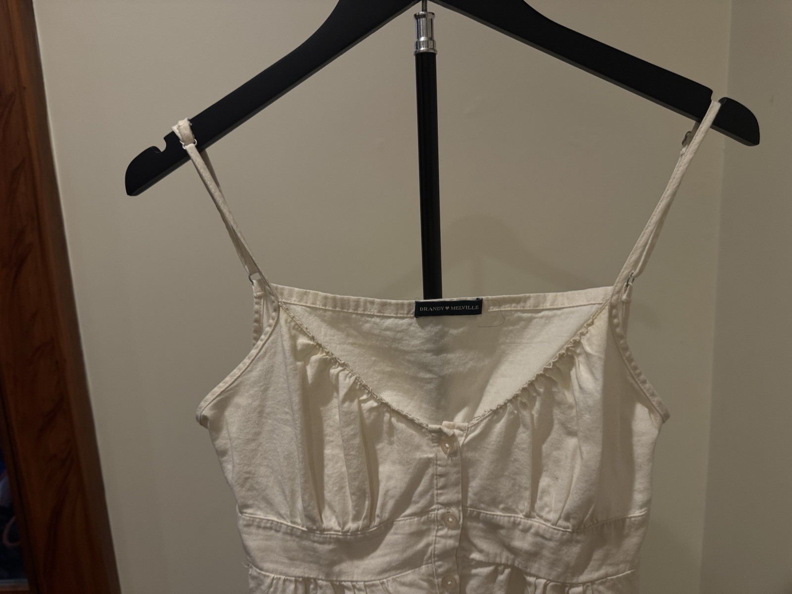 Brandy Melville cream camisole with thin adjustable spaghetti straps.