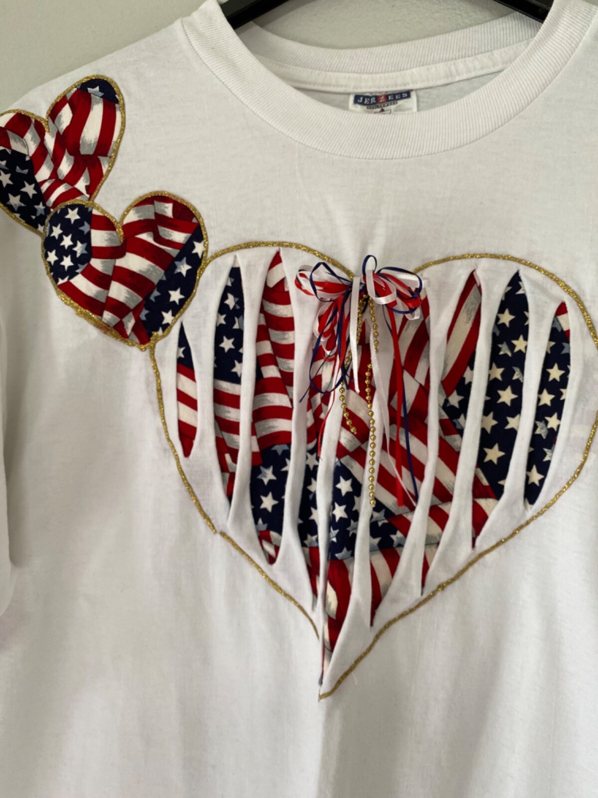 JERZEES WOMEN’S WHITE BOW AND HEART WITH A FLAG INSIDE PATRIOTIC SHIRT SIZE XL
