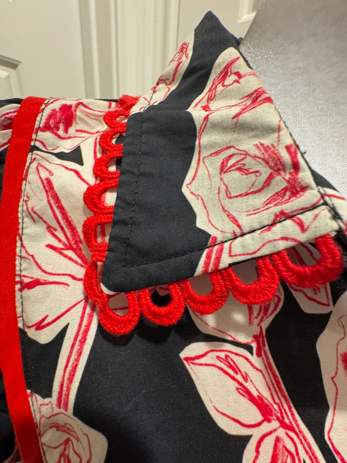 Entro top black floral print with red scalloped trim Sz Small
